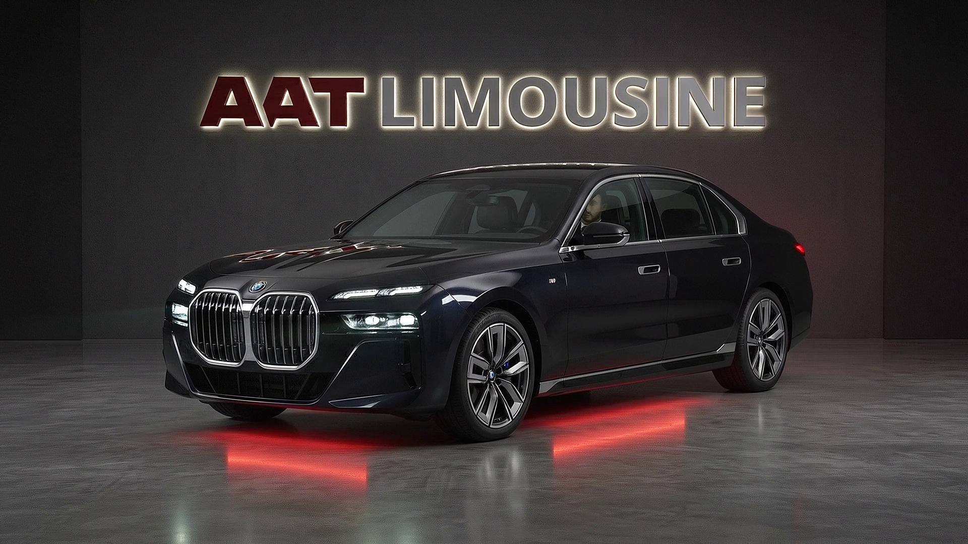 A black BMW 7 Series chauffeur car in a dark studio, headlights on, the AAT Limousine signature hero